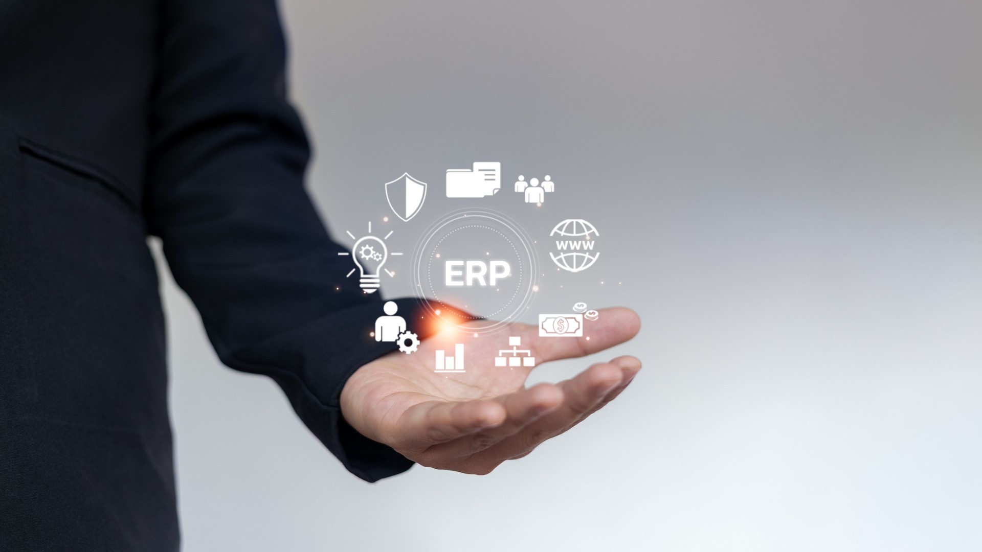 A businessman is holding an ERP interface surrounded by digital icons representing enterprise resource planning, data analytics, finance, HR, and system integration.